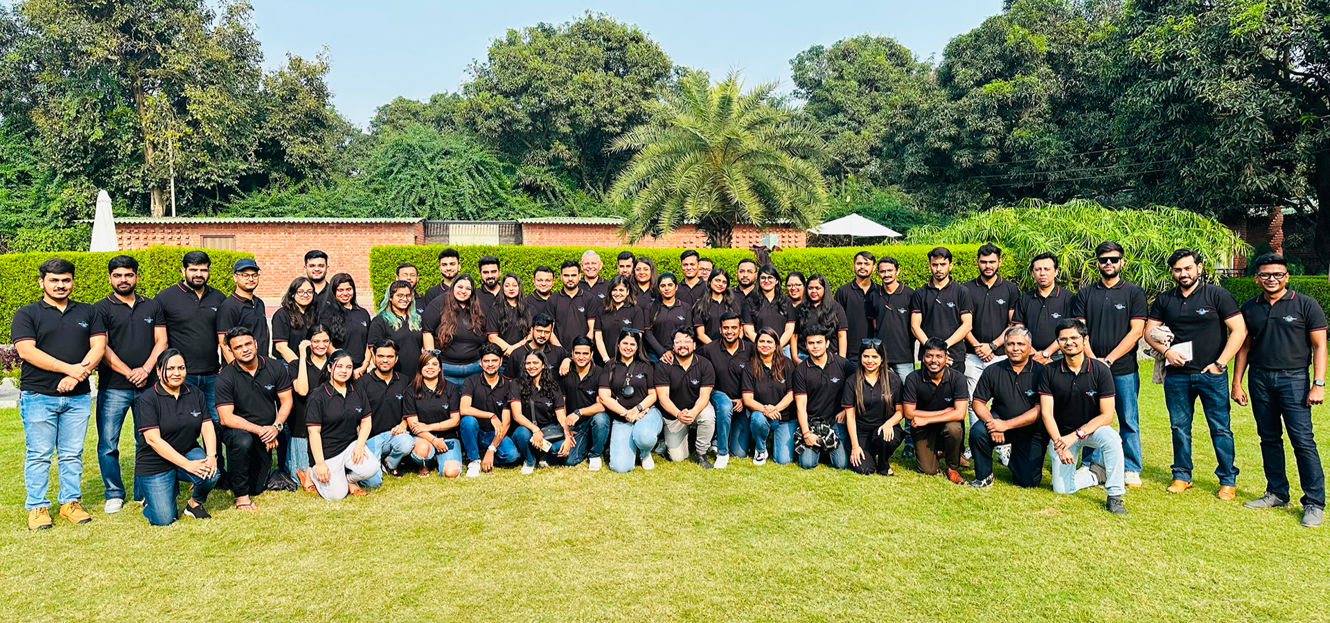 Gruppenbild des indischen Magic Billion-Teams auf einer Wiese vor begrüntem Hintergrund